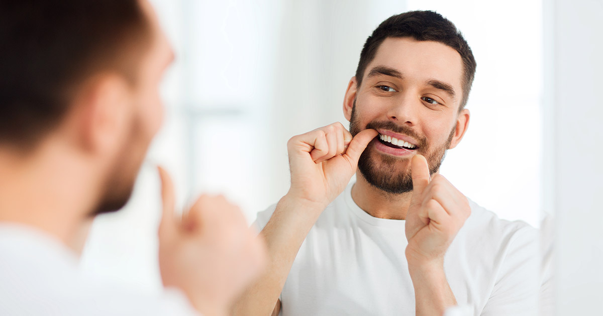 Man flossing teeth